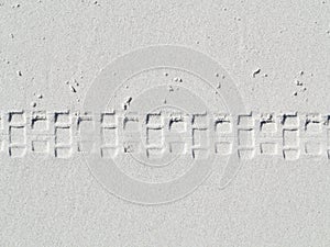 Pattern of wheel track in white sand of beach