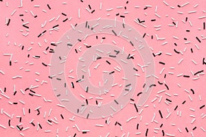 pattern of white and black sprinkles over pink background, sugar sprinkle dots