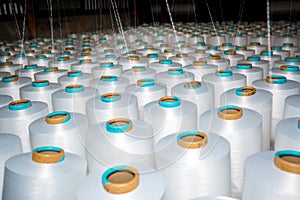 A pattern of white cotton spools with threads. An old system manual loom machine for clothing