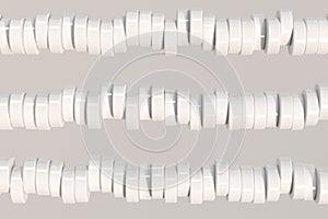 Pattern of white cylinder tablets on white background