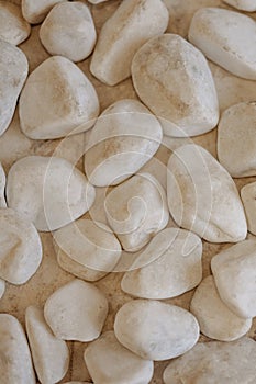 Pattern with white pebble sea stones on fine sand.