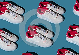 Pattern of white sneakers on a blue background. New sports shoes. Pair of casual fashion accessories