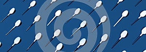 Pattern of white spoons on blue background