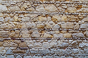 Pattern of yellow and gray decorative grunge weathered uneven stone wall surface