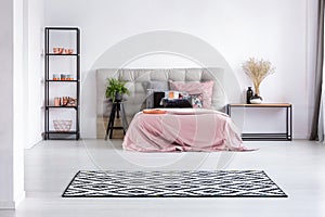 Patterned black and white rug on the floor of contemporary bedroom interior with comfortable bed