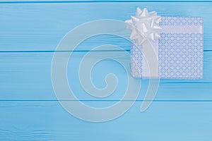 Patterned blue gift box on wood with copyspace.