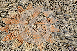 Patterned floor with sea pebbles red bricks and metal gears