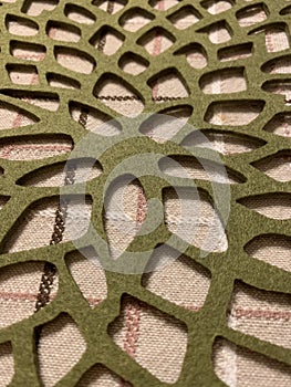 Patterned green felt tablecloth, abstract textured background, selective focus