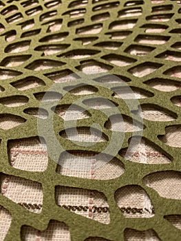 Patterned green felt tablecloth, abstract textured background, selective focus