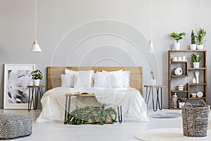 Patterned pouf and basket in bright bedroom interior with lamps,