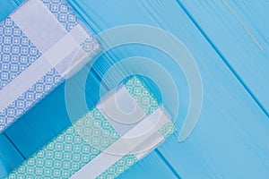 Patterned printed gift boxes on blue wood.