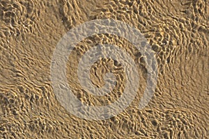 Patterns of sand and water with light reflections