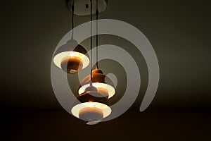 Patterns of three modern light lamps hanging on ceiling background