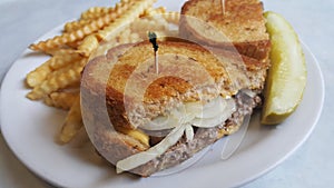 Patty melt with french fries and a dill pickle photo