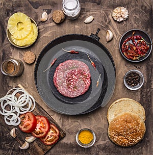 Patty of minced meat burger at home vintage pan for burger buns, tomato, onion wooden rustic background top view
