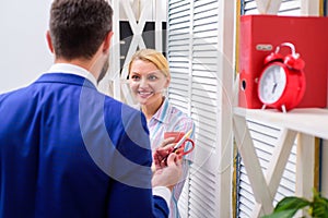 Pause business. Two of attractive business people, standing next to each other, holding a cups, smiling standing at