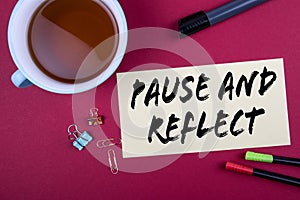 Pause and Reflect. Sheet of paper, teacup and stationery on a red table