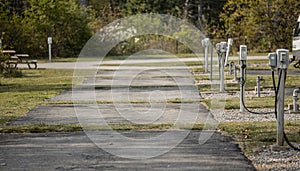 Paved pullthrough RV sites with power and water hookups in low season featuring empty spaces and blurred background