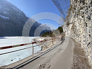 Paved road by the alpine resevoir lake KlÃ¶ntalersee Kloentalersee or Klontaler lake and in the KlÃ¶ntal alpine valley / Kloental