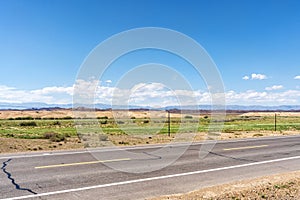 a paved road with no traffic on it under a bright blue sky