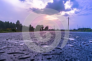 Paved road with raindrops at sunset in purple tone