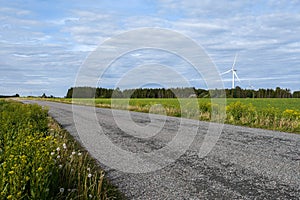 The paved road runs between fields of agricultural land