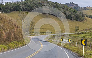 A paved road surrounded by mountains and trees in the south of the State of Minas Gerais, Brazil.