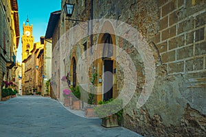 Paved street and entrances decorated with colorful flowers, Pienza, Italy