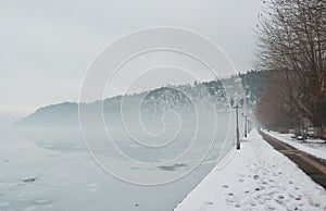 Pavement covered with snow on the banks of frozen lake Orestiada in Kastoria