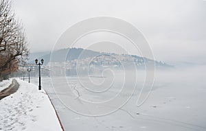 Pavement covered with snow on the banks of frozen lake Orestiada in Kastoria