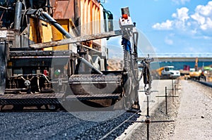 Pavement machine laying fresh asphalt or bitumen