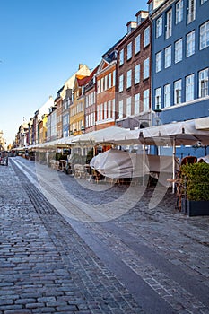 pavement and umbrellas at street cafe near beautiful colorful houses