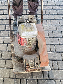 Paver with plate compactor