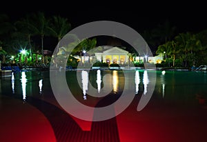 Pavilion with night illumination behind pool