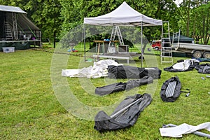 Pavilion for the sound system, tent poles and tarpaulins in bags for setting up an open-air music festival on the meadow, copy