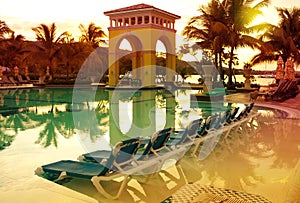 Pavilion on a sunset and the pool with reflection