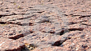 Paving blocks made of asymmetrical stone. Red wall with stone masonry, background, texture