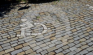 Paving of cubes forming the area of â€‹â€‹the parking lot with a mosaic in the shape of a wheelchair. reservations for handicapped