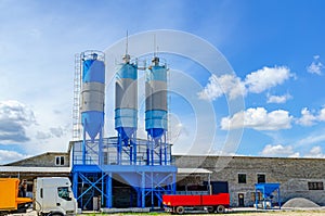 Paving plant. Industrial building with big blue tanks for cement, sand, water.  Panoramic photo