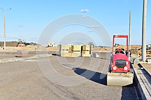 Paving roller machine during road work. Mini road roller at construction site for paving works. Screeding the sand for road