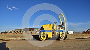 Paving roller machine during road work. Mini road roller at construction site for paving works. Screeding the sand for road