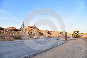 Paving roller machine during road work. Road roller at construction site for paving works. Screeding the sand for road concreting