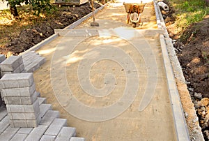 Paving slabs or paving stones are laid out on the sand between the curbstone.