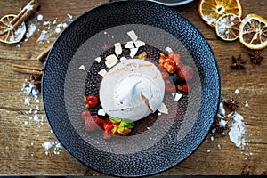 Pavlova berry cake with passion cream, strawberry, meringue. Delicious sweet dessert food closeup served for lunch in