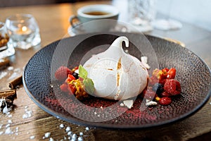 Pavlova berry cake with passion cream, strawberry, meringue. Delicious sweet dessert food closeup served for lunch in