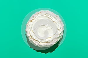 Pavlova cake in bright light, isolated on a green background