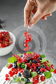 Pavlova cake with cream and fresh summer berries. Close up of Pavlova dessert with forest fruit and mint. Food photography. The