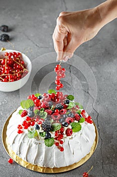 Pavlova cake with cream and fresh summer berries. Close up of Pavlova dessert with forest fruit and mint. Food photography. The