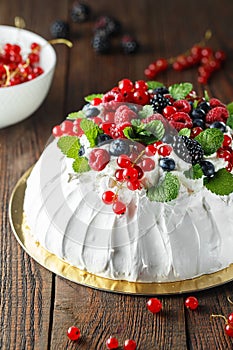 Pavlova cake with cream and fresh summer berries. Close up of Pavlova dessert with forest fruit and mint