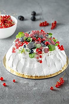 Pavlova cake with cream and fresh summer berries. Close up of Pavlova dessert with forest fruit and mint